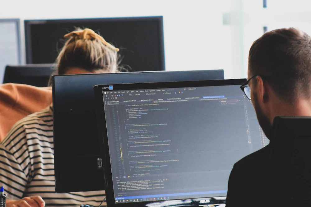 Software developer writing code on a monitor